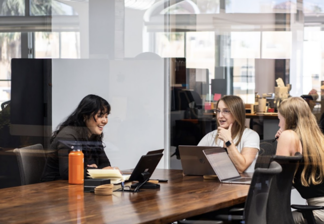 Three women in a meeting room talking